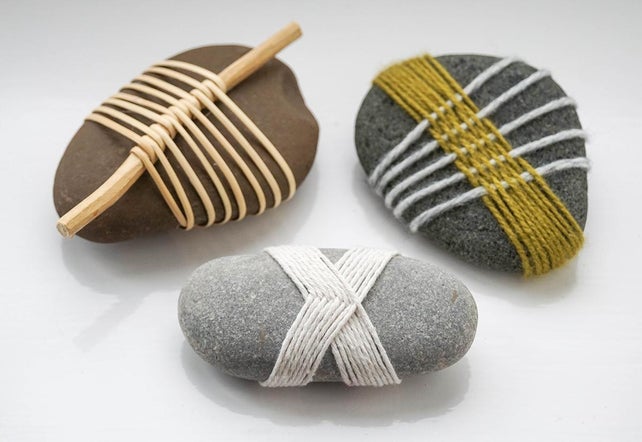 image of three stones, wrapped in woven yarn strands