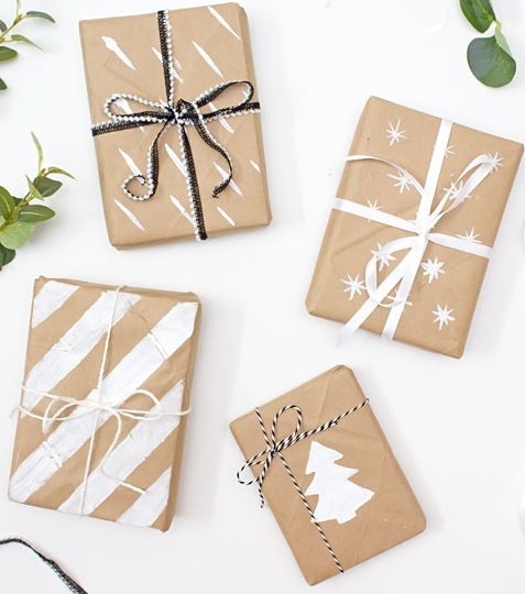 picture of 4 boxes wrapped in beige butcher paper, with white paint decoration.