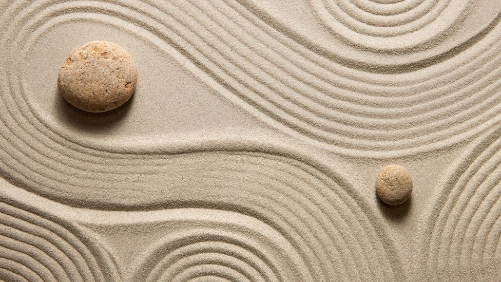 rocks in sand that has been raked in a pattern