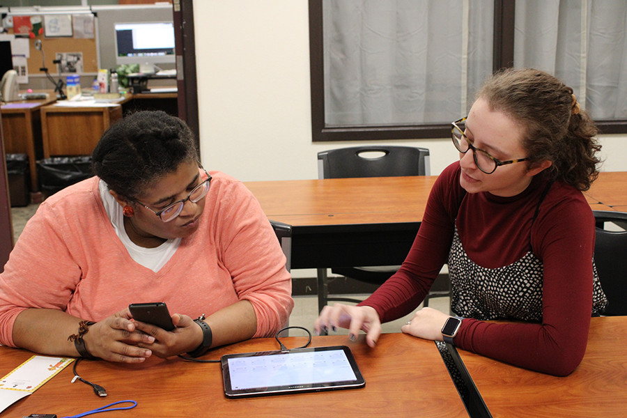 Librarian helping a woman with a tablet