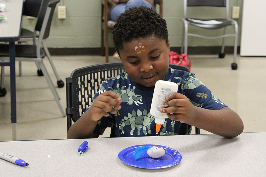 Young boy using blue to make slime during a STEAM learning program
