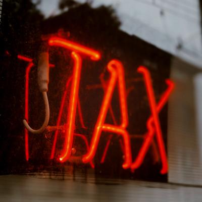 Red lighted sign that says "tax"