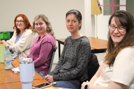 Group of four women sitting at a table in the library