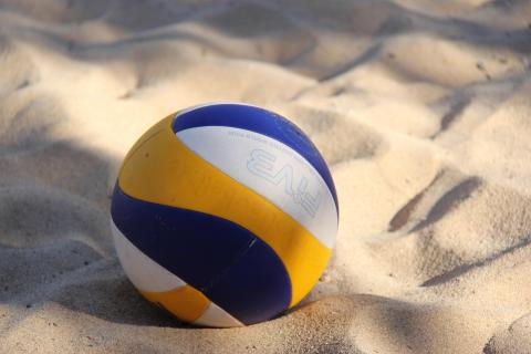 yellow & blue volleyball in sand