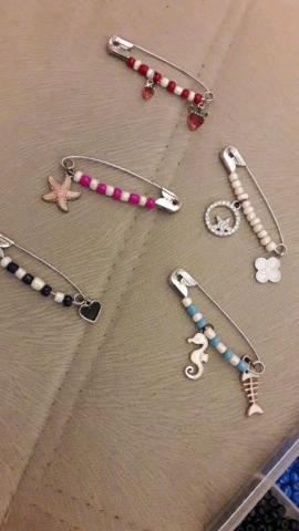 Safety pins with various colorful beads and some charms on them