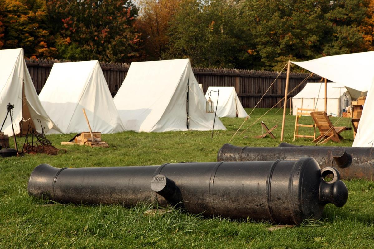 old campground with tents and a cannon
