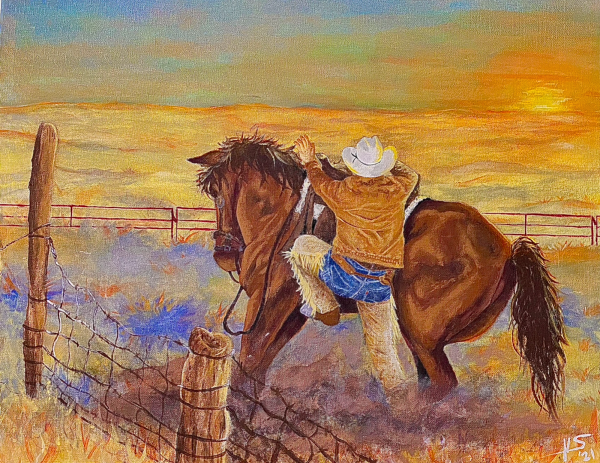 Cowboy getting on horse at sunrise