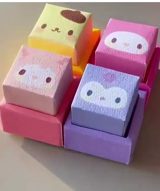 Four clicker toys with different character designs are next to each other in a square.