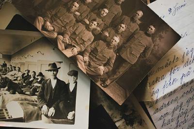 Pile of older black and white photos and a handwritten cursive note.