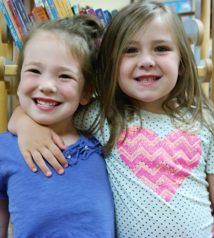 Two girls in library stacks